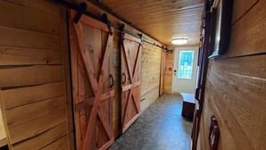 Un couloir en bois avec un sol carrelé et une porte dotée d’une fenêtre.