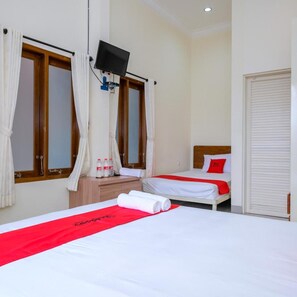 A hotel room with two beds, a TV mounted on the wall, and a window with curtains. - OYO 3314 Syariah House (Purwokerto)