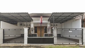 A gated entrance with a metal roof and a sign above the door. - OYO 3267 Omah Suryo (Yogyakarta)