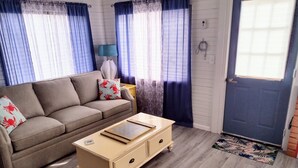 Una sala de estar con un sofá, una mesa de centro y una puerta.