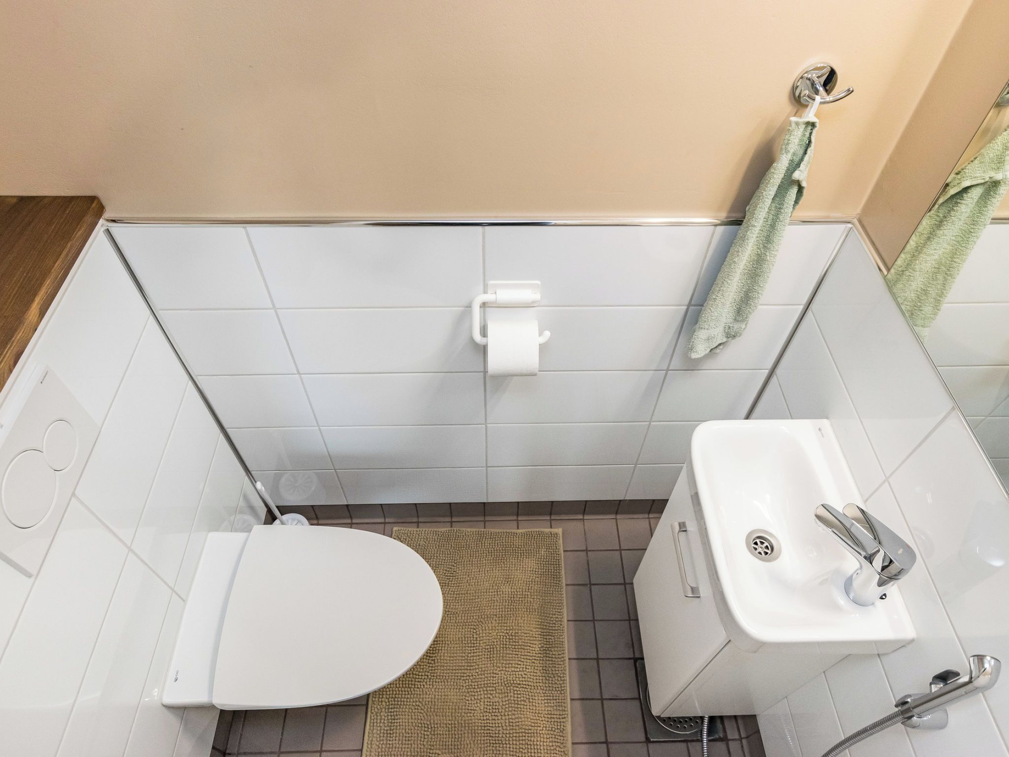 Ein kleines Badezimmer mit Toilette, Waschbecken und Handtuchhalter.