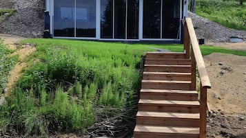 Una escalera de madera que conduce a un edificio moderno con ventanas amplias.