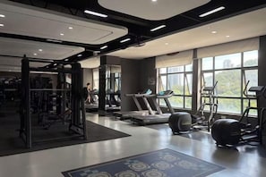 A gym with treadmills, a squat rack, and exercise balls. - Wonderful Hotel (Huidong)