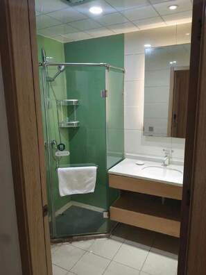 A modern bathroom with a glass-enclosed shower, a white sink, and a mirror. - Greentree Inn Jinan Licheng District Fenghuang Road East High-speed Railway Station (Jinan)