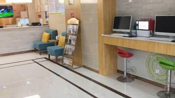 A reception area with a counter, seating, and computers.