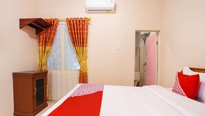 A hotel room with a bed, a wardrobe, a shower, and an air conditioning unit. - OYO 3252 Lansano Residence (Padang)