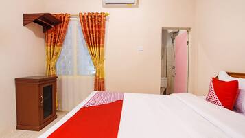 Una habitación de hotel con cama, armario, ducha y aire acondicionado.