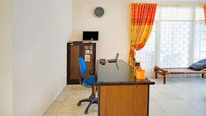 A room with a desk, chair, bed, and a window with curtains. - OYO 3252 Lansano Residence (Padang)