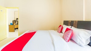 A hotel room with a bed, a desk, and a chair. - OYO 3252 Lansano Residence (Padang)
