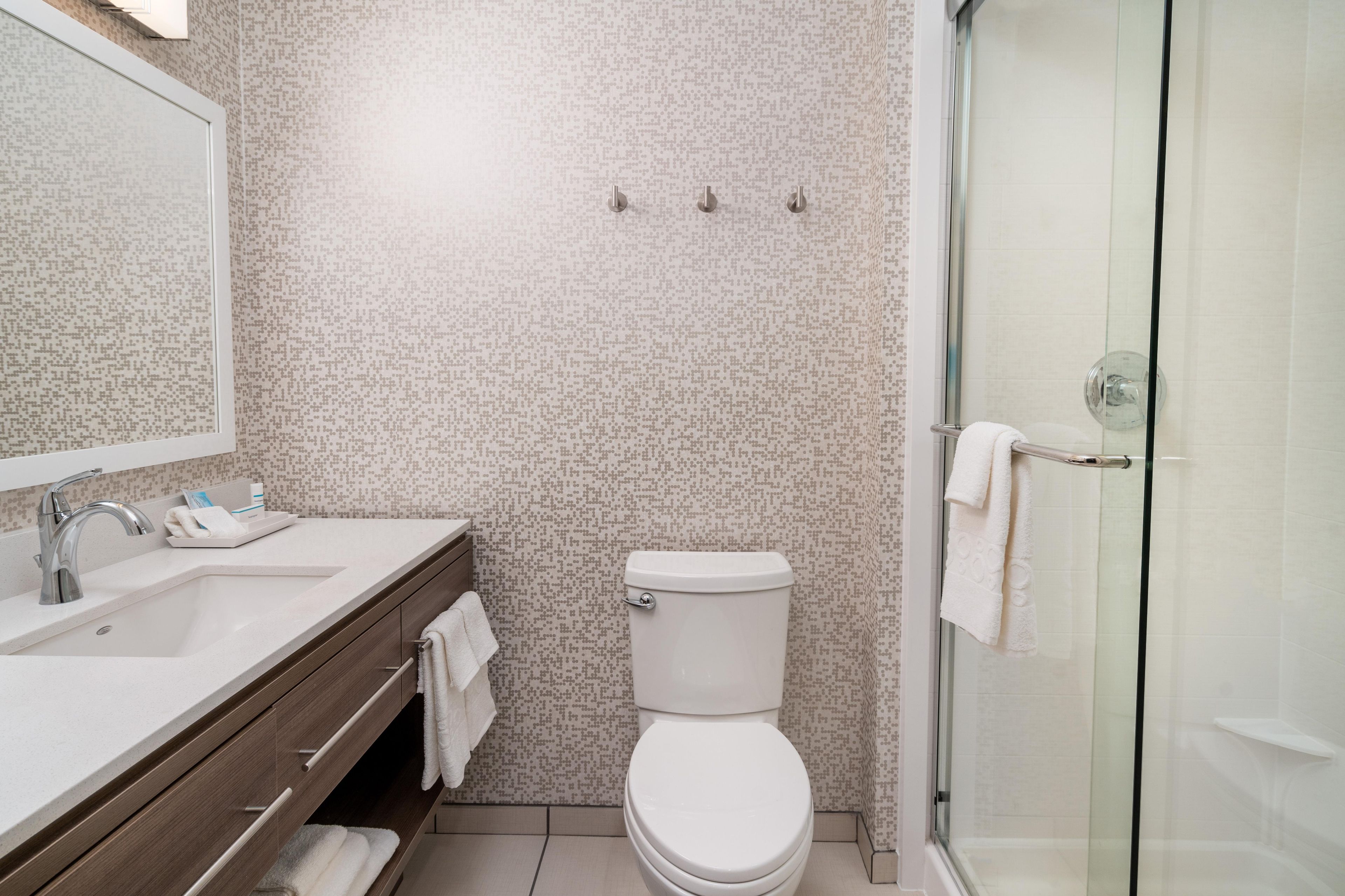 A modern bathroom with a shower, toilet, and sink.