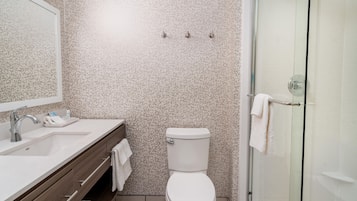 A modern bathroom with a shower, toilet, and sink.