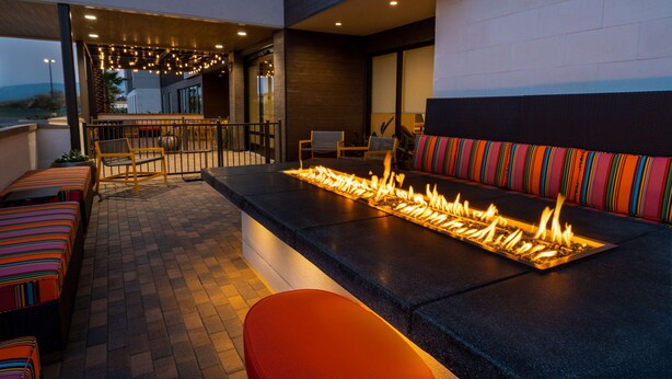 Eine Außenpatio mit Feuerstelle, Sitzgelegenheiten und einer Bar.