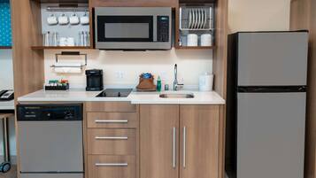 Uma cozinha moderna equipada com micro-ondas, máquina de café e lava-louças.
