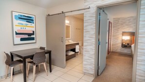 Ein Hotelzimmer mit Essbereich, Bad und Flur.
