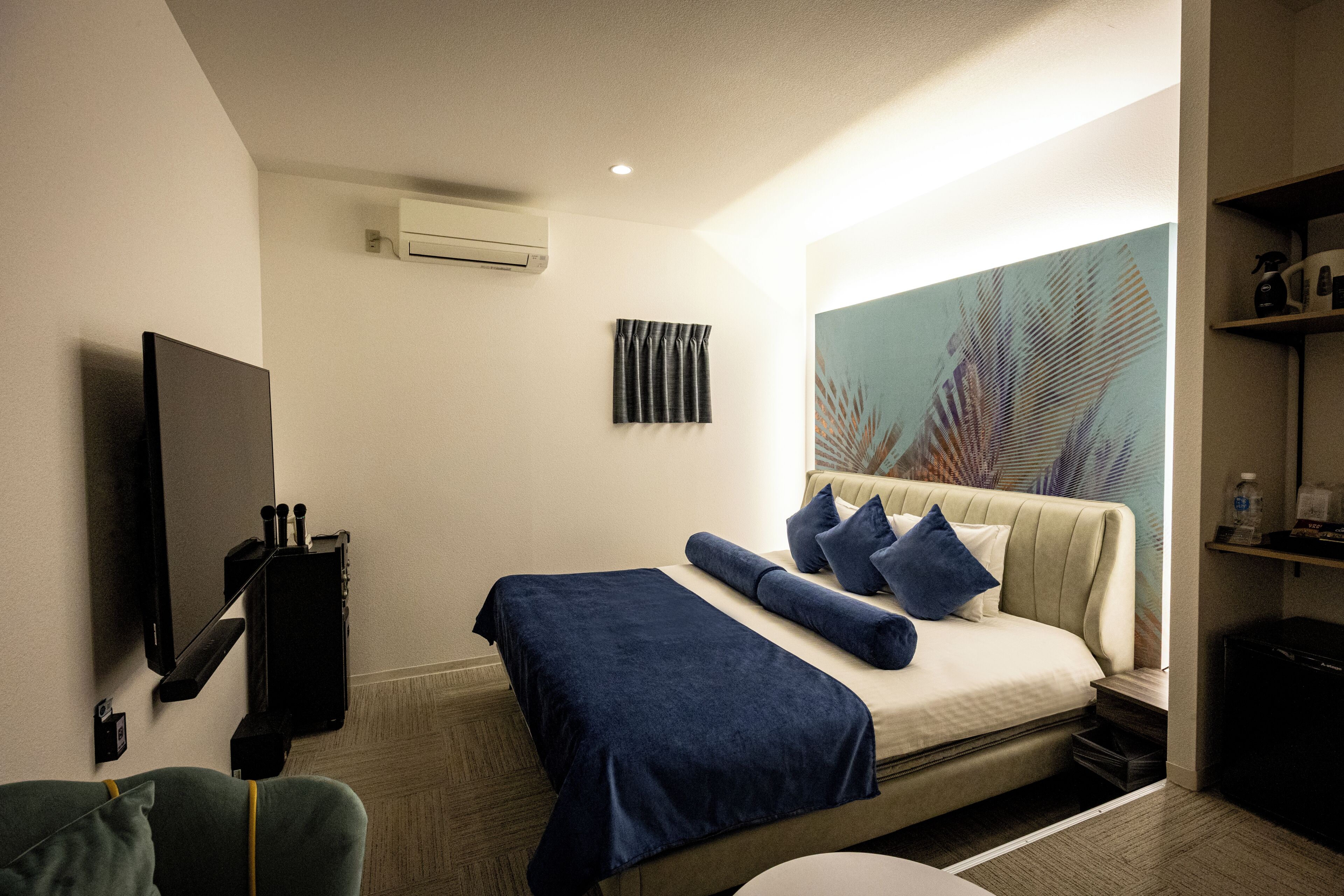 Habitación de hotel con cama, televisor de pantalla plana en la pared, una mesita y un ventanal con vistas.