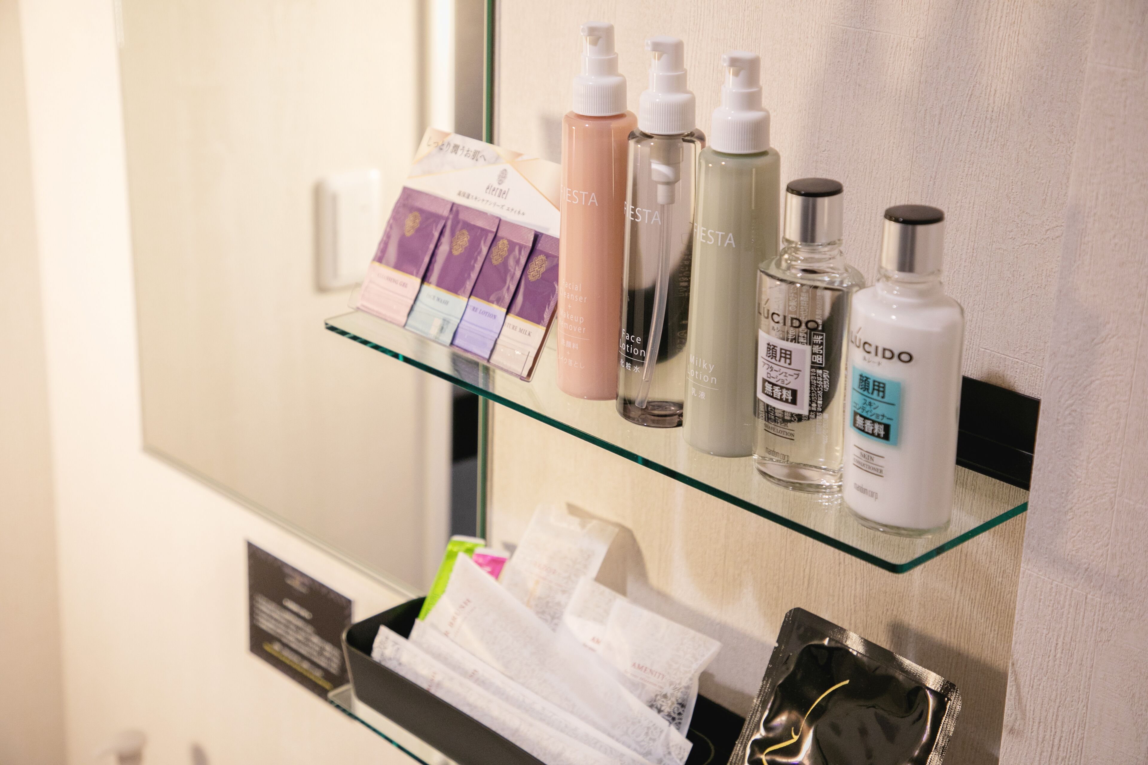 A glass shelf with various toiletries and a card.