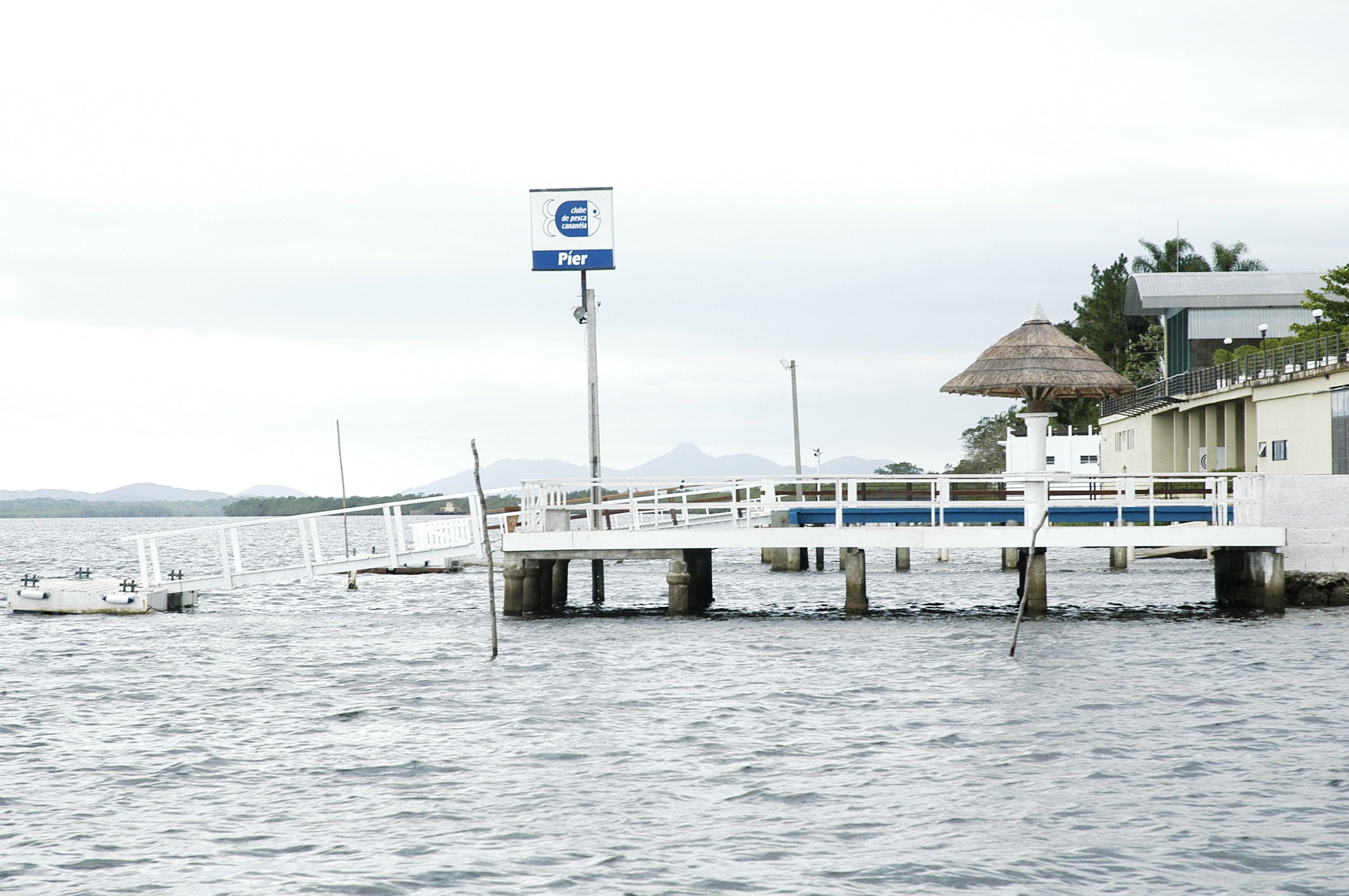 A pier extending into calm waters with a sign indicating a pier.