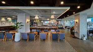 Een modern restaurant met een bar, zitplaatsen en een vloer met patroon.