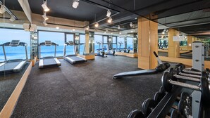 Een sportschool met loopbanden, hometrainers en krachttoestellen.