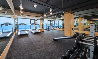 A gym with treadmills, exercise bikes, and weight machines.