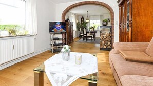 En stue med fjernsyn, sofa, sofabord og pejs.