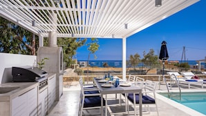 An outdoor dining area with a pool, a grill, and a view of the sea. - Constantinos Villa, Sublime Island Εscape.Walking distance to the beach & shops (Panormos in Rethymno)