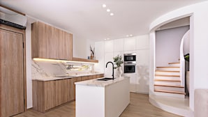 A modern kitchen with a central island, wooden cabinets, and built-in appliances. - Constantinos Villa, Sublime Island Εscape.Walking distance to the beach & shops (Panormos in Rethymno)