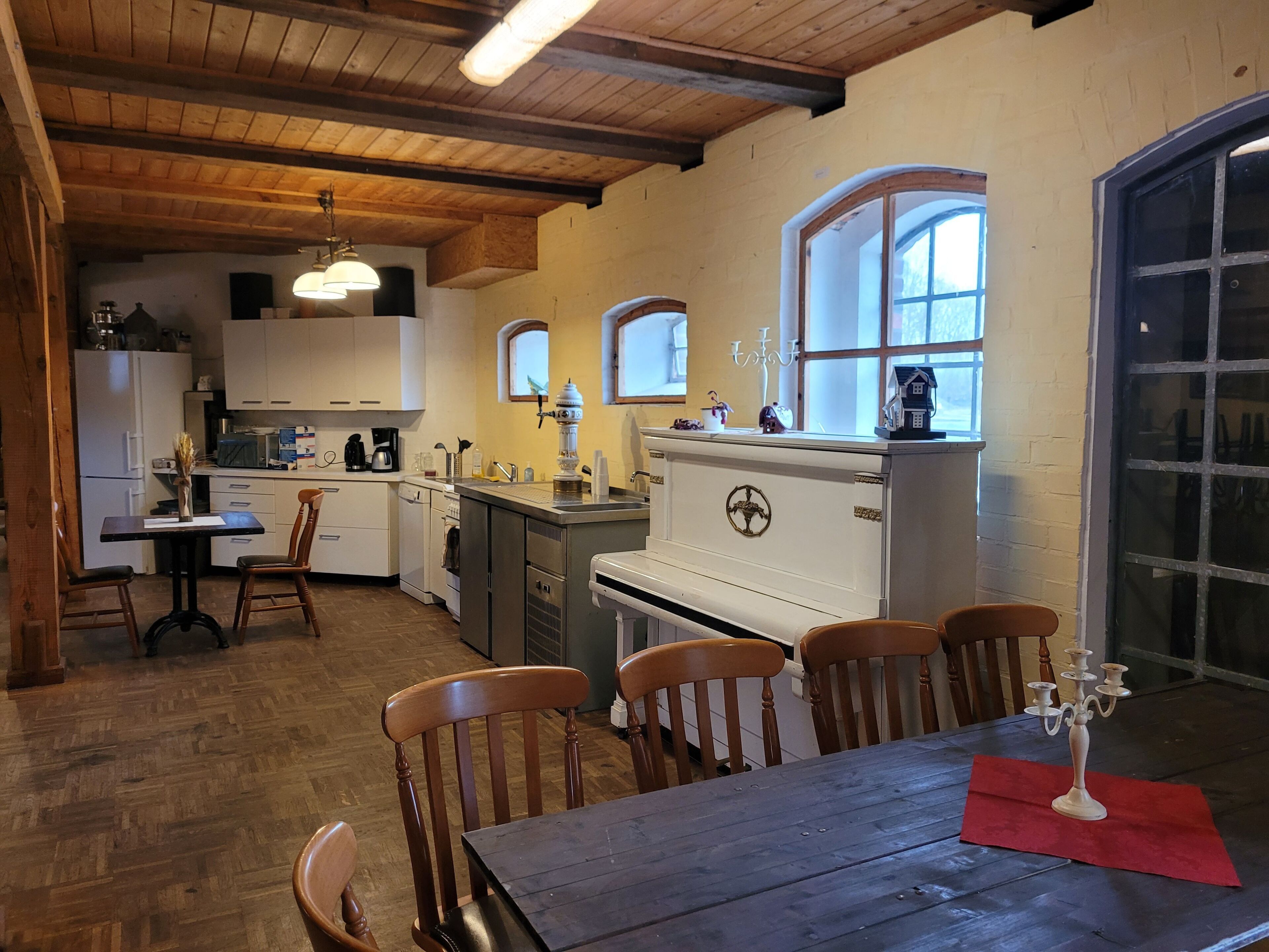 Una cocina con armarios de madera, una mesa de comedor con sillas y una ventana con vistas.