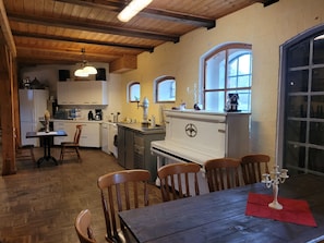 Ett kök med träskåp, ett matbord med stolar och ett fönster med utsikt.