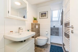 Regadera, secadora de cabello, toallas, papel de baño 