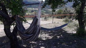 A hammock tied between trees in a natural setting with a view of a hilly landscape. - peggy's tiny (Sisteron)