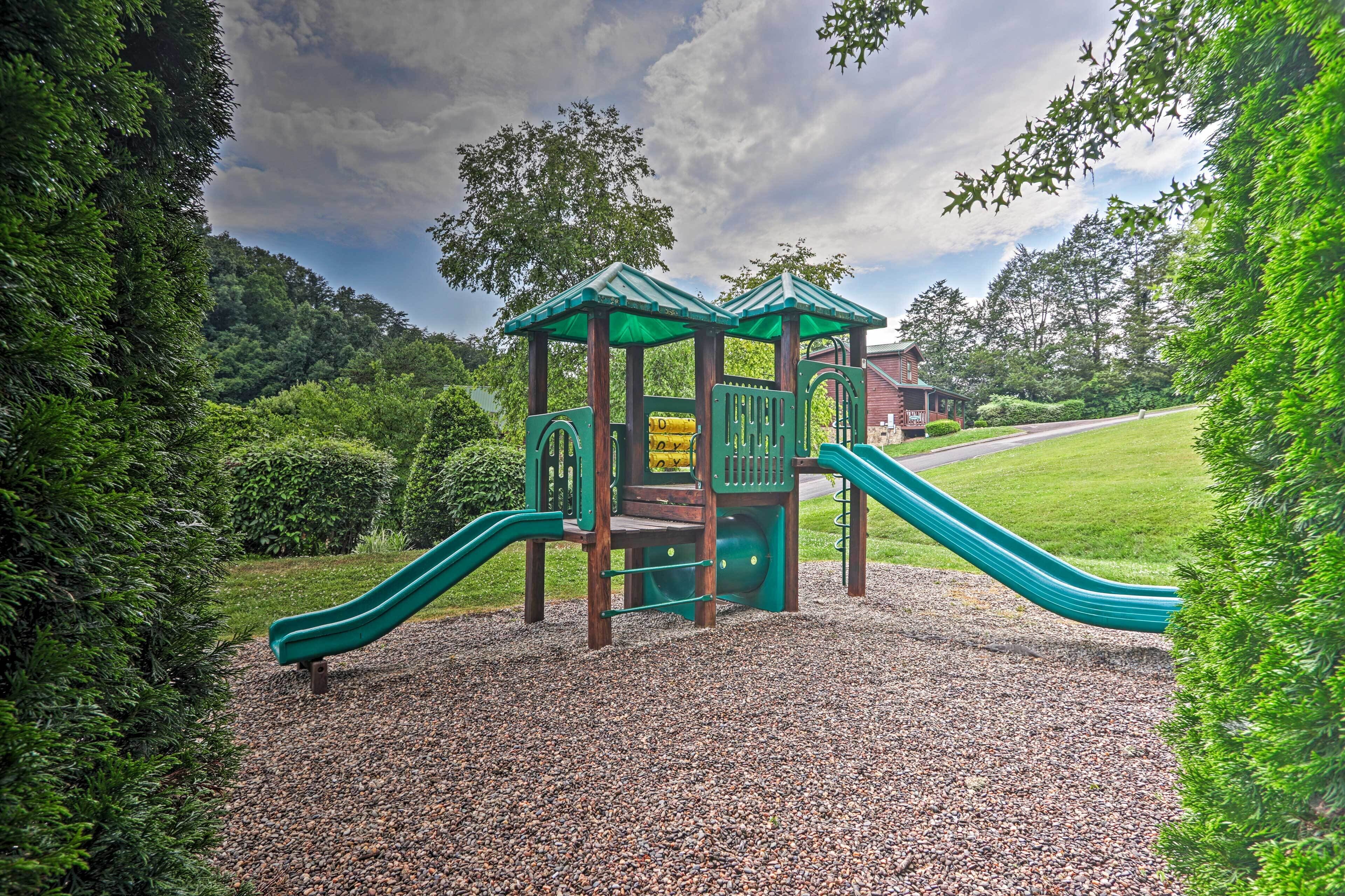 A playground with a green slide and a climbing structure.