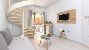 A modern living room with a spiral staircase, a sofa, a small table with a hat, and a TV mounted on the wall.
