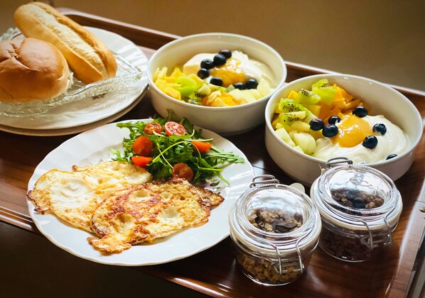 Ein Frühstückswagen mit Eiern, Toast, Obstschalen und einem Salat.