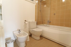 Een bad/douchecombinatie, een haardroger, een bidet, zeep