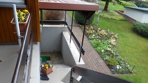 Una scala residenziale conduce a un'area esterna coperta con un giardino.