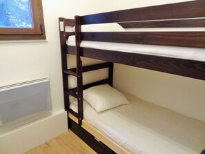 A bunk bed with a window above it, a radiator below, and a wooden floor. - At the foot of slopes, 3 rooms, pets allowed (Les Deux Alpes)