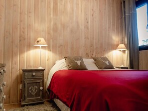 A wooden-paneled room with a bed, two bedside lamps, and a small cabinet. - At the foot of slopes, 3 rooms, pets allowed (Les Deux Alpes)