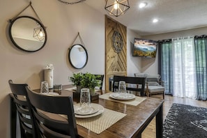Enjoy meals in this stylish dining area with a table for four, a large mirror, and a beautiful view.