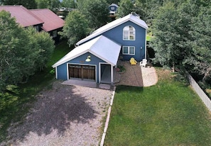 A two-story house with a garage, a covered porch, and a well-maintained lawn. - Butte Beauty, Quaint East End Home in CB. Hot tub (Crested Butte)
