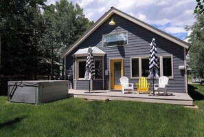 A small cabin with a porch, two Adirondack chairs, and a covered grill area. - Butte Beauty, Quaint East End Home in CB. Hot tub (Crested Butte)