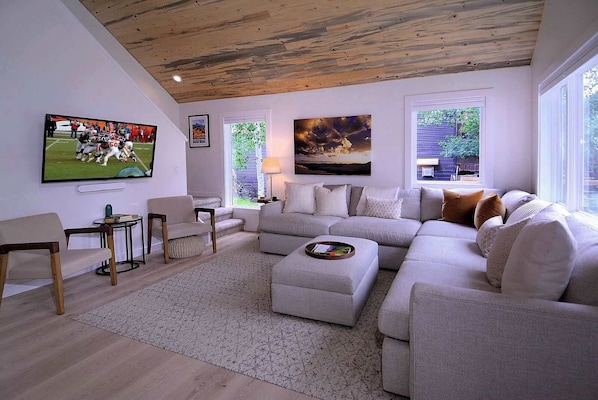 A modern living room with a sectional sofa, a flat-screen TV, and artwork on the walls. - Butte Beauty, Quaint East End Home in CB. Hot tub (Crested Butte)