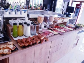 A buffet with various food items and condiments. - Hotel Nevada (Constanta)