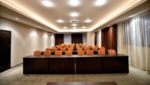 A conference room with a long table and multiple chairs, a projector, and curtains. - Hotel Nevada (Constanta)