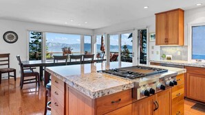 A kitchen with a large island, wooden cabinets, and a view of the mountains. - Dynamic Views, Hot Tub, Gym, 2nd Living Room, Garage and More. (Carnelian Bay)