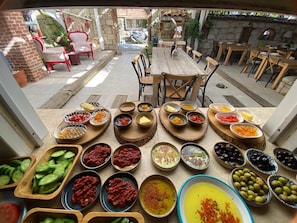Enjoy a casual dining experience in our outdoor patio area, surrounded by stone walls and beautifully presented dishes.
