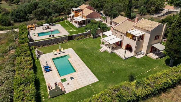 A villa with a swimming pool, a garden, and a view of the sea.