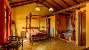A four-poster bed with a wooden canopy, a stone floor, and a wooden ceiling.