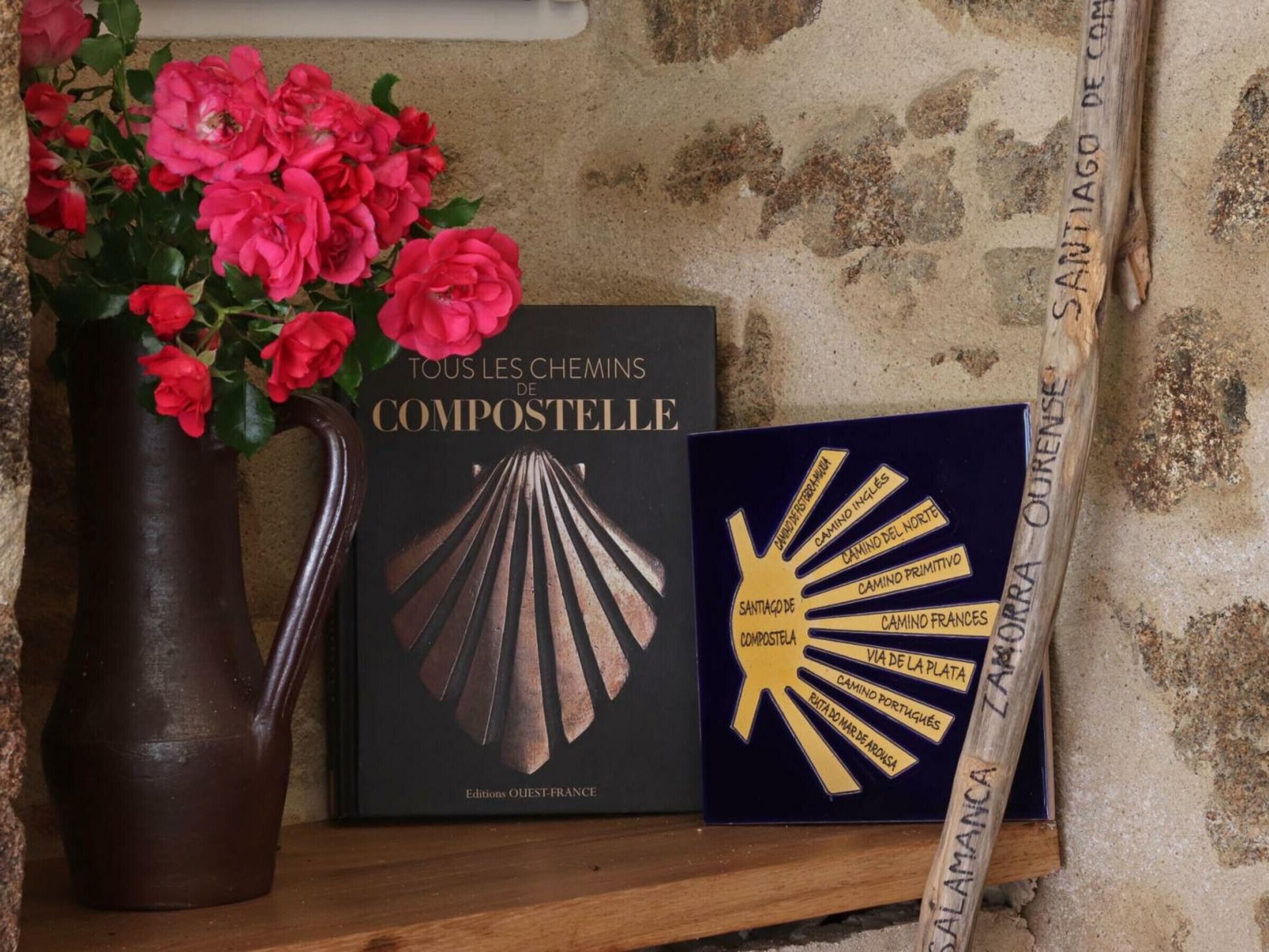 Un livre intitulé « Tous les chemins de Compostelle » et une carte intitulée « Saint-Jacques-de-Compostelle ».