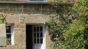 Un edificio de piedra con una ventana y una puerta.